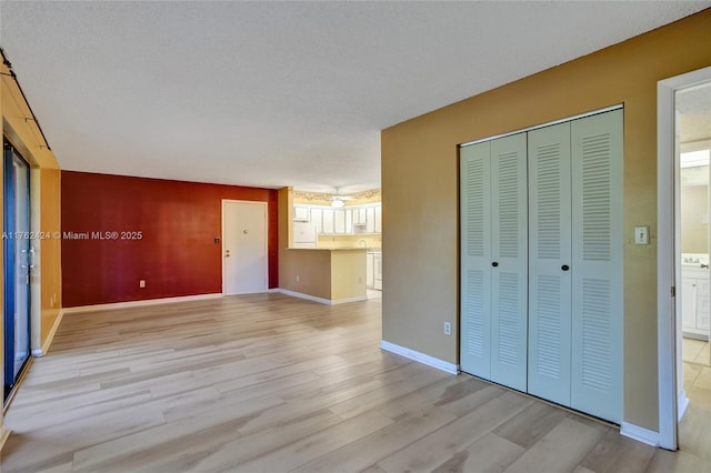 interior space with baseboards and light wood-style flooring