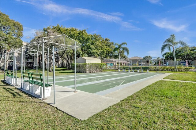 surrounding community featuring shuffleboard and a yard