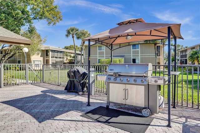 view of patio featuring a gazebo, a grill, and fence