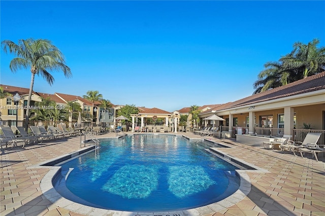 pool with a patio area and a residential view