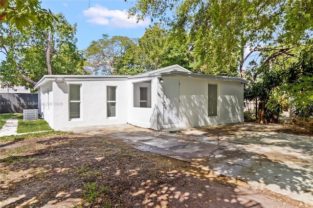 back of house featuring a patio, central air condition unit, fence, and stucco siding