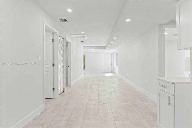 hall with recessed lighting, visible vents, and baseboards