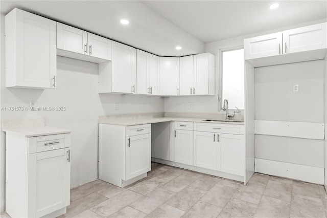 kitchen with a sink, white cabinetry, and recessed lighting
