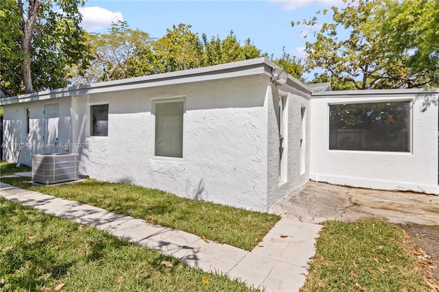 view of property exterior with central AC unit and stucco siding