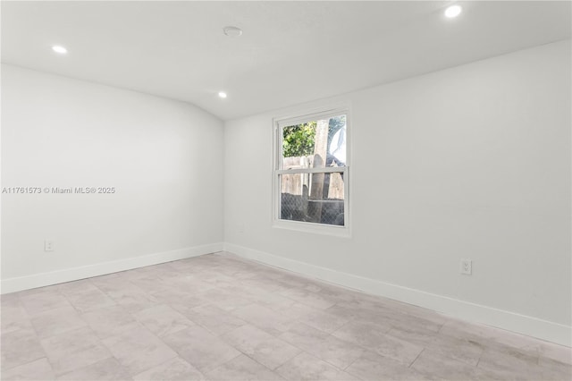 spare room with baseboards, vaulted ceiling, and recessed lighting