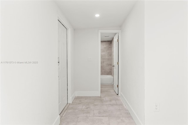 corridor with baseboards and recessed lighting