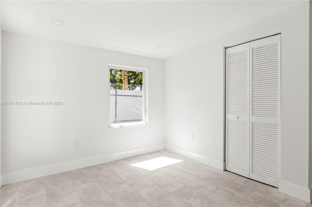 unfurnished bedroom with recessed lighting, a closet, and baseboards