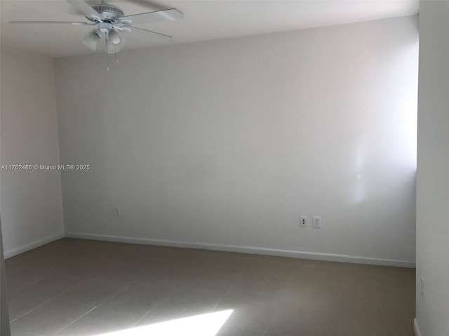 tiled spare room featuring baseboards and ceiling fan