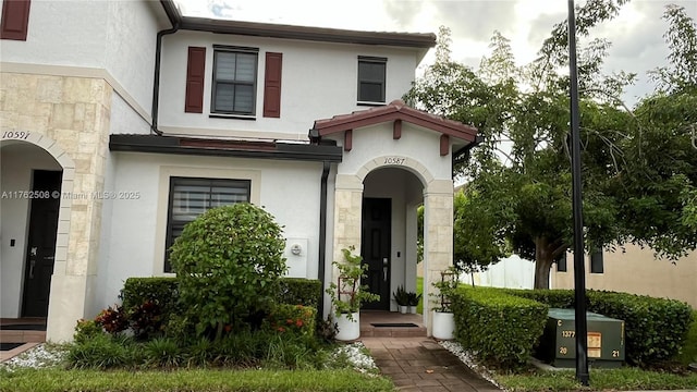 view of front of home featuring stucco siding and stone siding