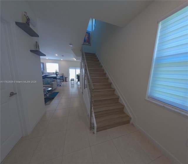 staircase featuring tile patterned floors and baseboards