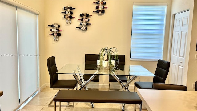 dining space featuring tile patterned floors, baseboards, and a healthy amount of sunlight