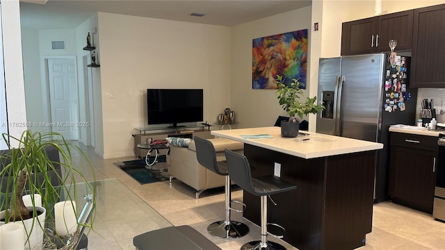 kitchen with visible vents, a kitchen breakfast bar, a center island, and light countertops