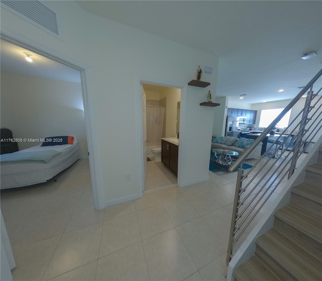 stairway featuring visible vents, baseboards, and tile patterned flooring