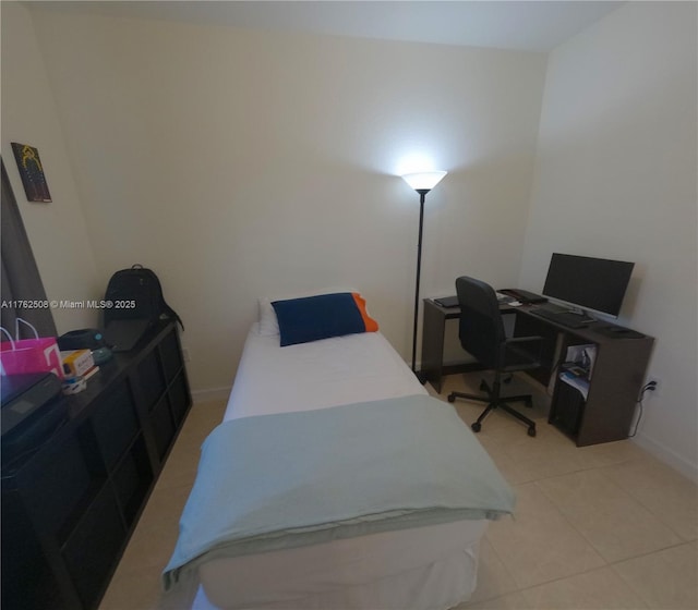 bedroom with light tile patterned floors and baseboards