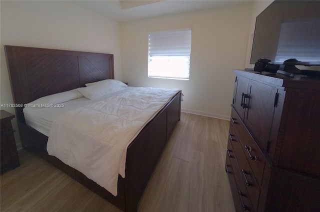 bedroom featuring baseboards and light wood-style floors