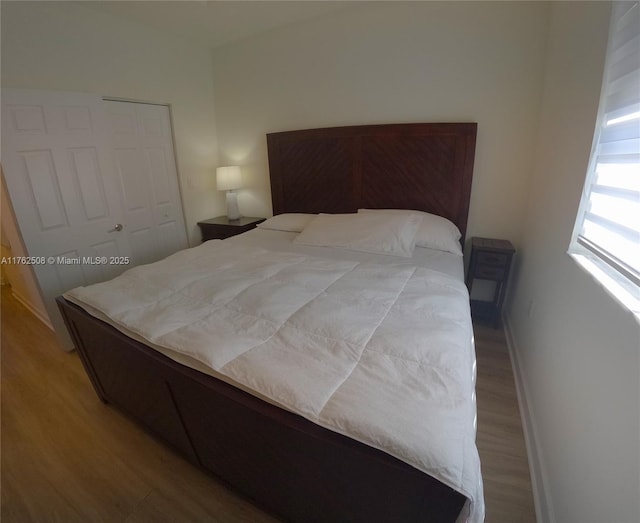 bedroom featuring a closet, baseboards, and wood finished floors