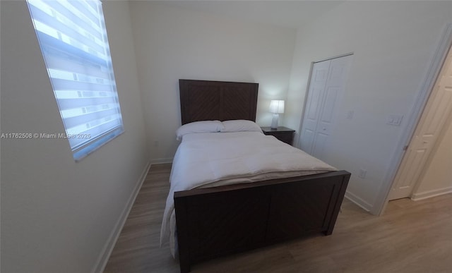 bedroom featuring a closet, baseboards, and light wood-style flooring