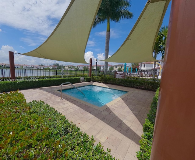 view of swimming pool with a patio area, a water view, and fence