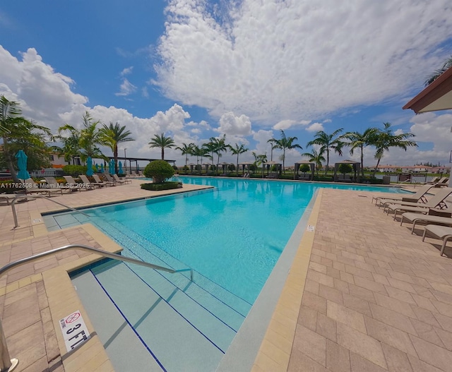 pool featuring fence and a patio area