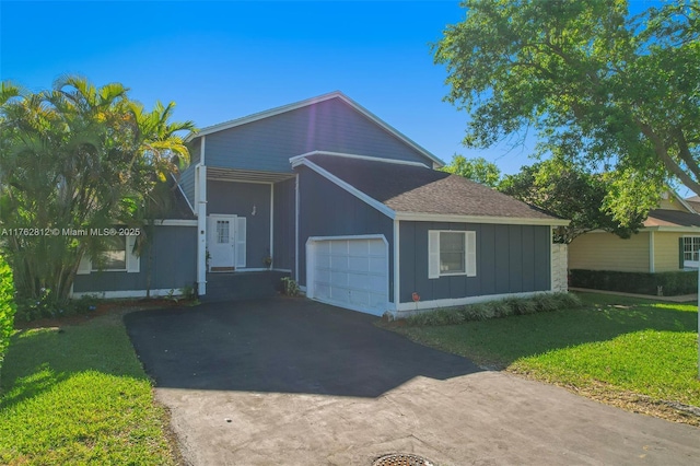 view of side of property with a lawn, aphalt driveway, board and batten siding, a shingled roof, and a garage