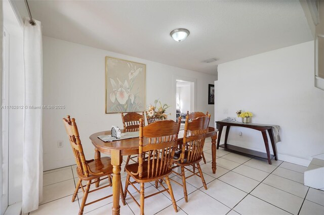 dining space featuring light tile patterned floors and visible vents