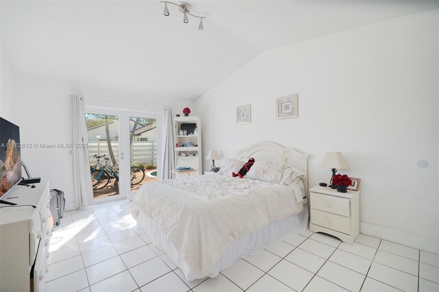 bedroom featuring light tile patterned floors, baseboards, lofted ceiling, and access to outside