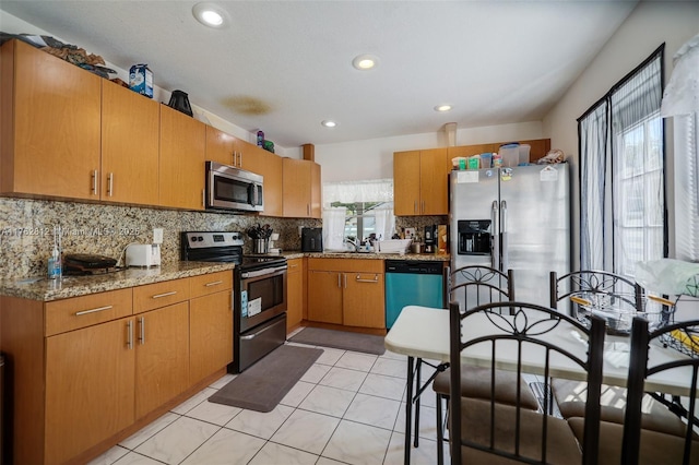 kitchen featuring a sink, backsplash, recessed lighting, stainless steel appliances, and light tile patterned floors