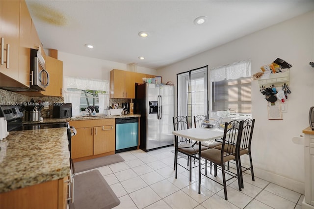 kitchen with light tile patterned floors, recessed lighting, a sink, decorative backsplash, and appliances with stainless steel finishes