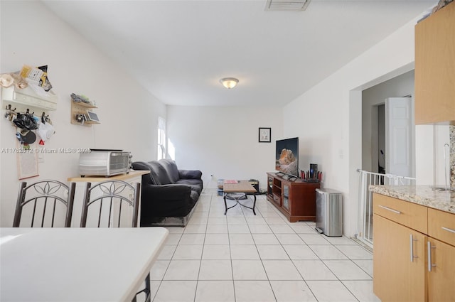 living area featuring light tile patterned flooring and visible vents