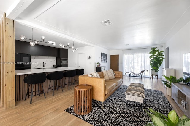 living area featuring visible vents and light wood-style floors