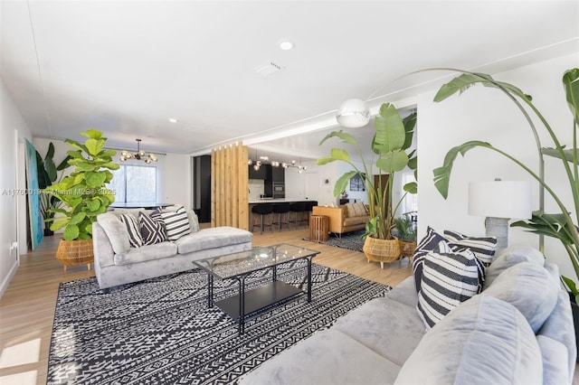 living room with light wood-style floors and a chandelier