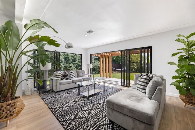 living area featuring wood finished floors, visible vents, and baseboards