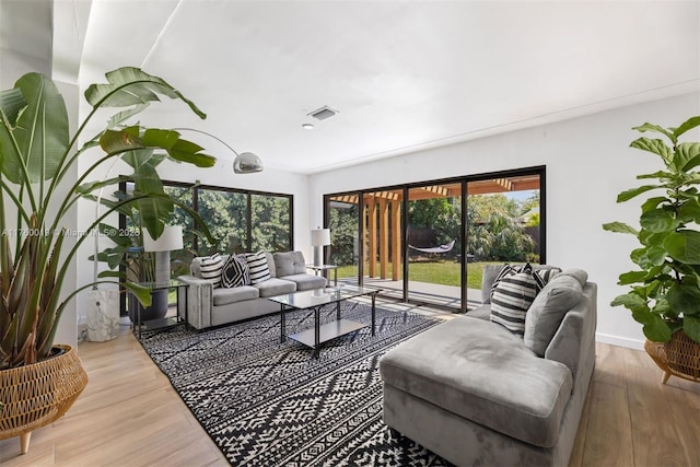 living room with visible vents, baseboards, and wood finished floors