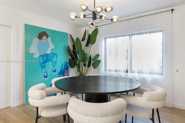 dining area with plenty of natural light, baseboards, light wood-type flooring, and a chandelier