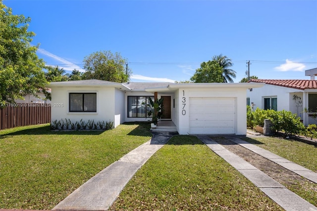 view of front of property with stucco siding, driveway, a front lawn, fence, and a garage