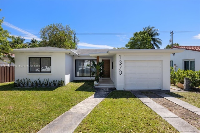 view of front of property with stucco siding, driveway, fence, a front yard, and a garage