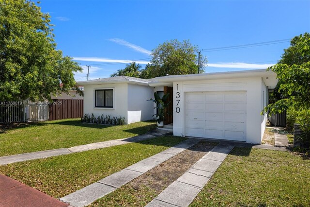 ranch-style house featuring stucco siding, driveway, fence, a front yard, and an attached garage