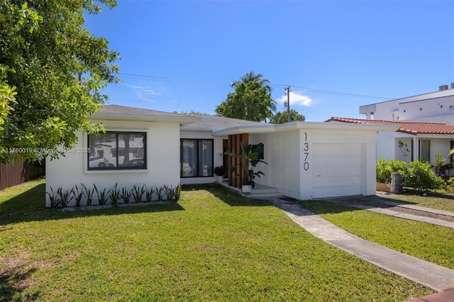 view of front of property with stucco siding, driveway, a front yard, and an attached garage