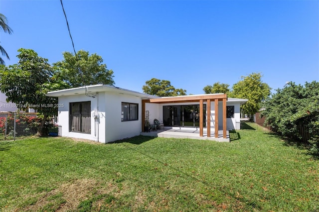 back of property featuring a yard, a patio, fence, and stucco siding