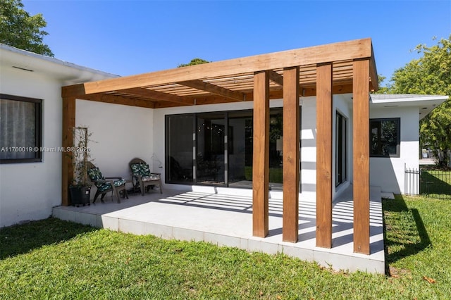 rear view of property featuring stucco siding, a patio area, a lawn, and a pergola