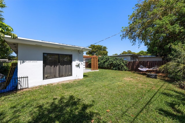 view of yard featuring an outdoor structure and fence