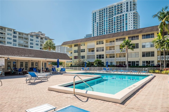 community pool with a patio and fence