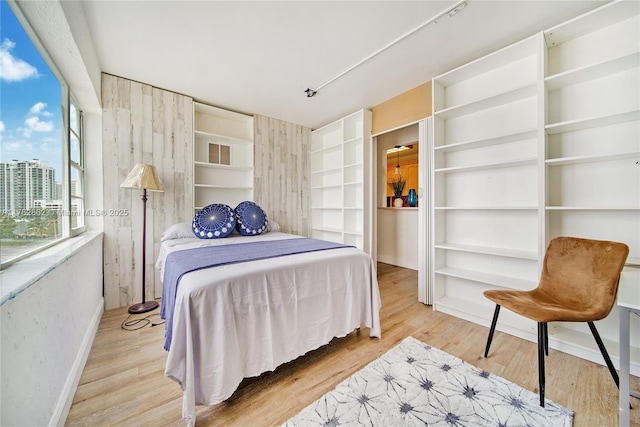 bedroom with baseboards and wood finished floors