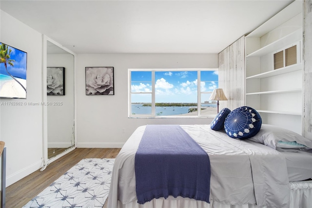 bedroom with baseboards and wood finished floors