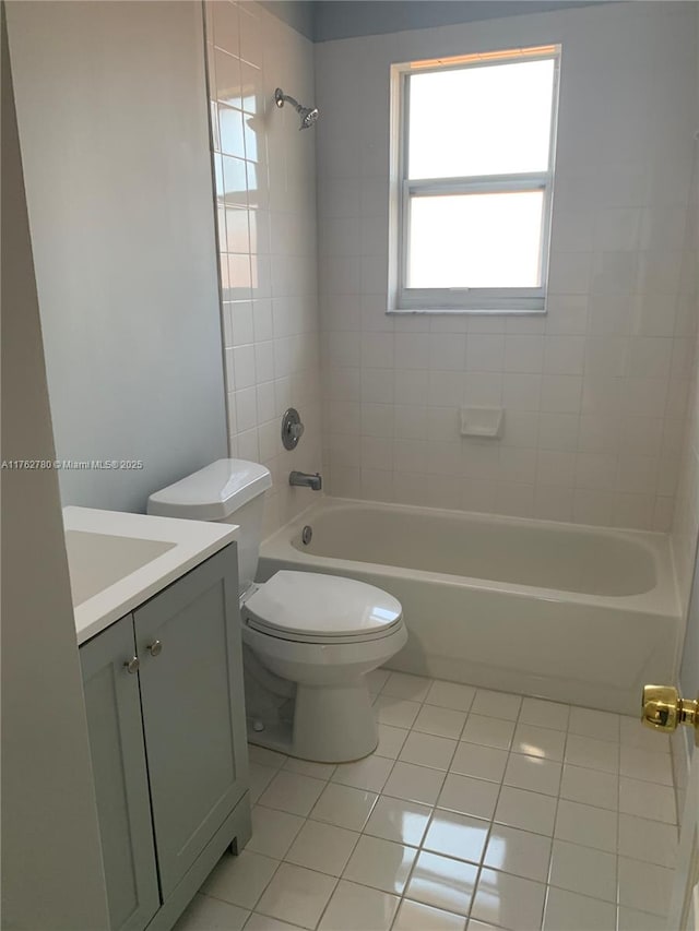 full bath featuring vanity, bathing tub / shower combination, toilet, and tile patterned floors