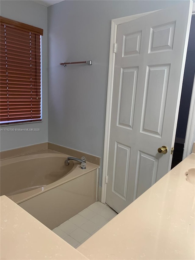 bathroom with tile patterned floors and a garden tub