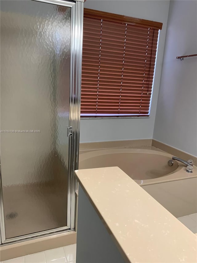 bathroom with a garden tub and a stall shower