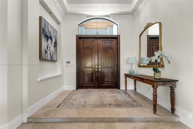 foyer entrance featuring tile patterned floors, baseboards, and ornamental molding