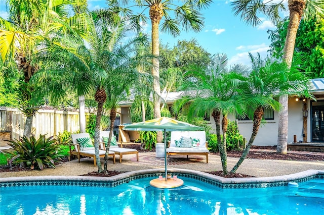 outdoor pool featuring a patio and fence