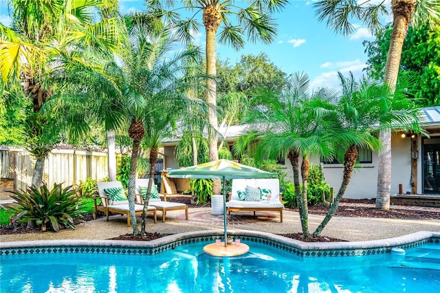 outdoor pool with a patio and fence